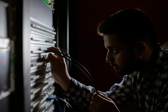 Engineer connecting cables in a server rack